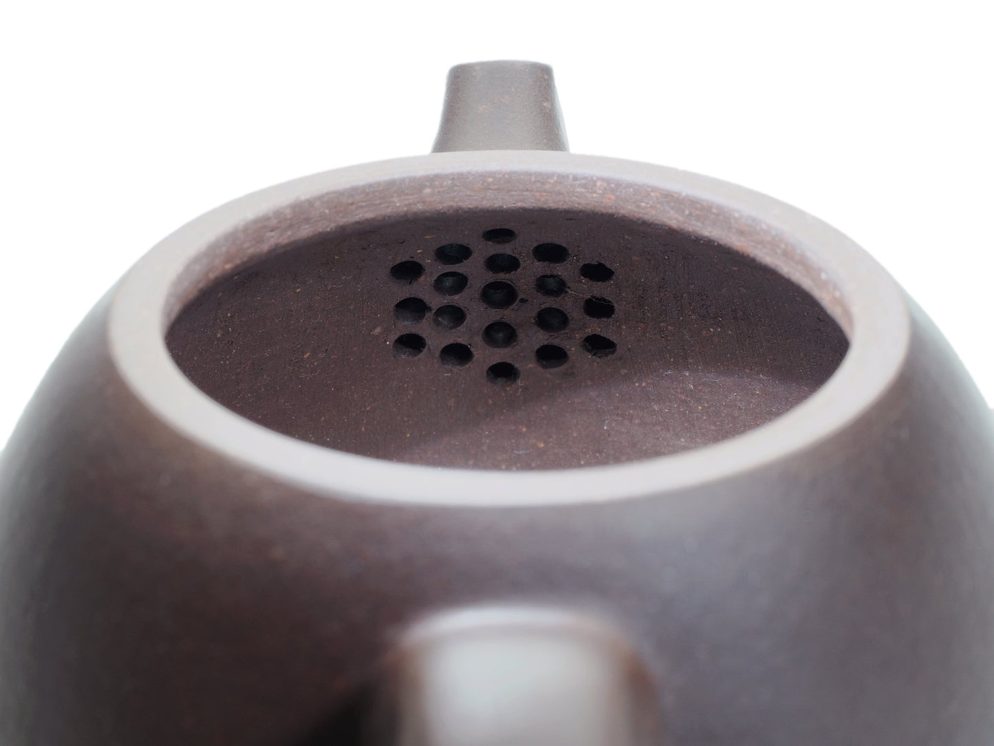 Close‑up of the Da Long Dan teapot’s interior with a built‑in multi‑hole filter near the spout for smooth, even pouring.