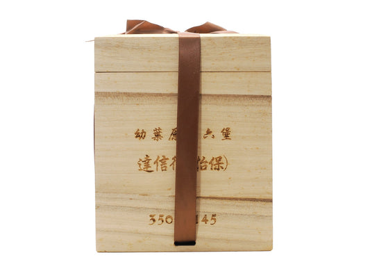 Front view of Daxinhang Liu Bao tea in wooden box with brown ribbon