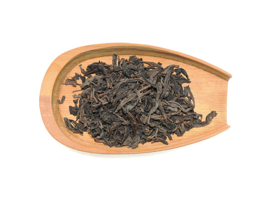 Dry Fo Shou tea leaves displayed on a bamboo tray