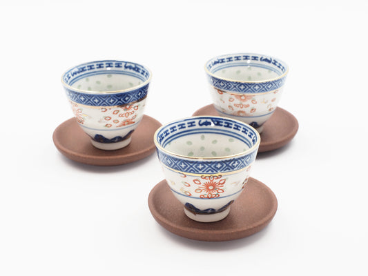 Dehou-style Lao Zini coasters shown with patterned porcelain Gongfu teacups