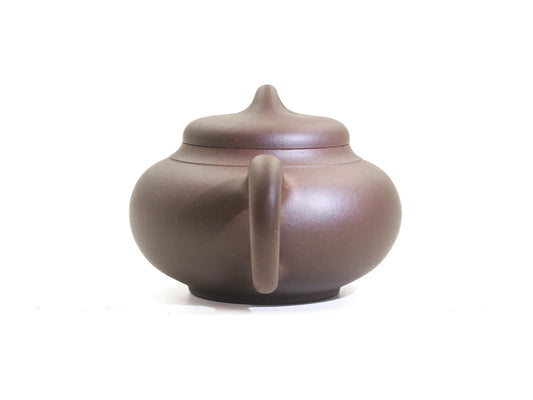 Back view of the Yun Tong Hu Yixing teapot, 260 ml, in bronze-grade purple clay (zisha), looking along the handle toward the domed lid and ring knob
