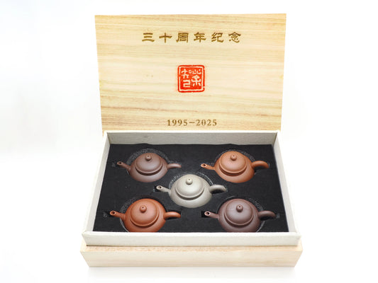 Open wooden presentation box for the 30th Anniversary "Five Blessings" Teapot Set, displaying the "1995-2025" engraving and five Mo Yuan Zhai teapots.