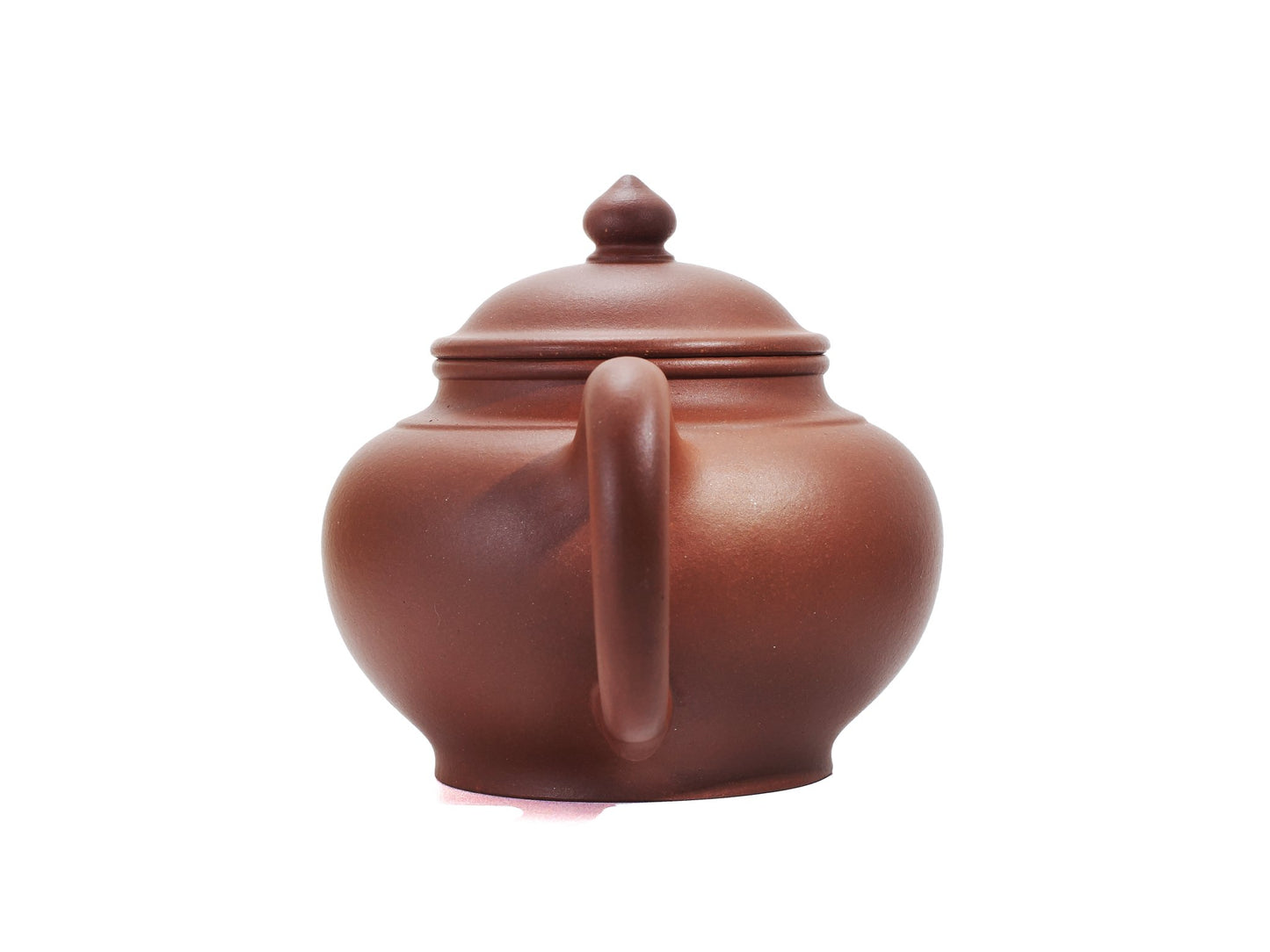 Back view of the Zhao Zhuang Hong Ni Xiao Ying Hu teapot focusing on the rounded handle and the smooth red clay body.