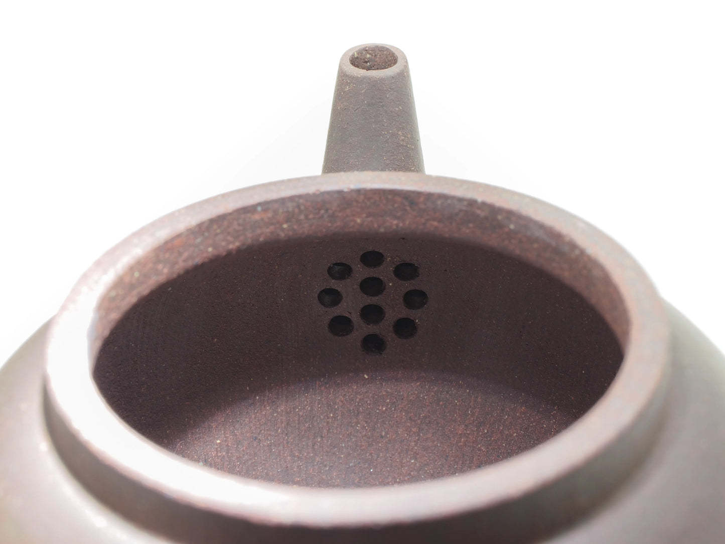 Close-up of the internal filter holes inside the Jade Grade teapot, showing the clean and precise clay work.