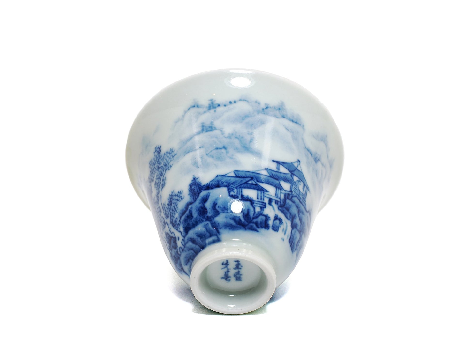 Base view showing artist's signature on blue and white landscape teacup