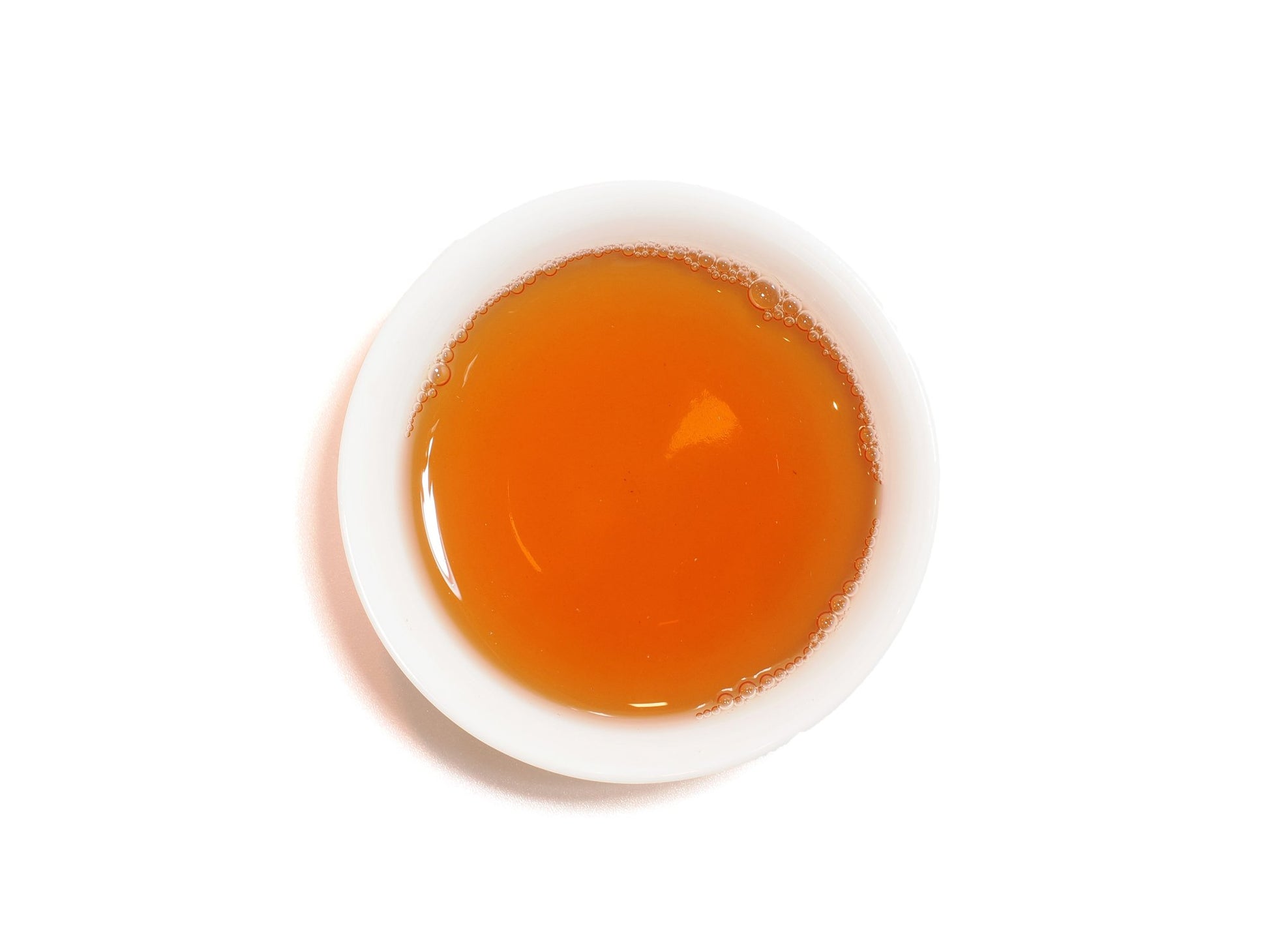 Amber liquor of Lao Cong Shui Xian oolong in a white cup, top view
