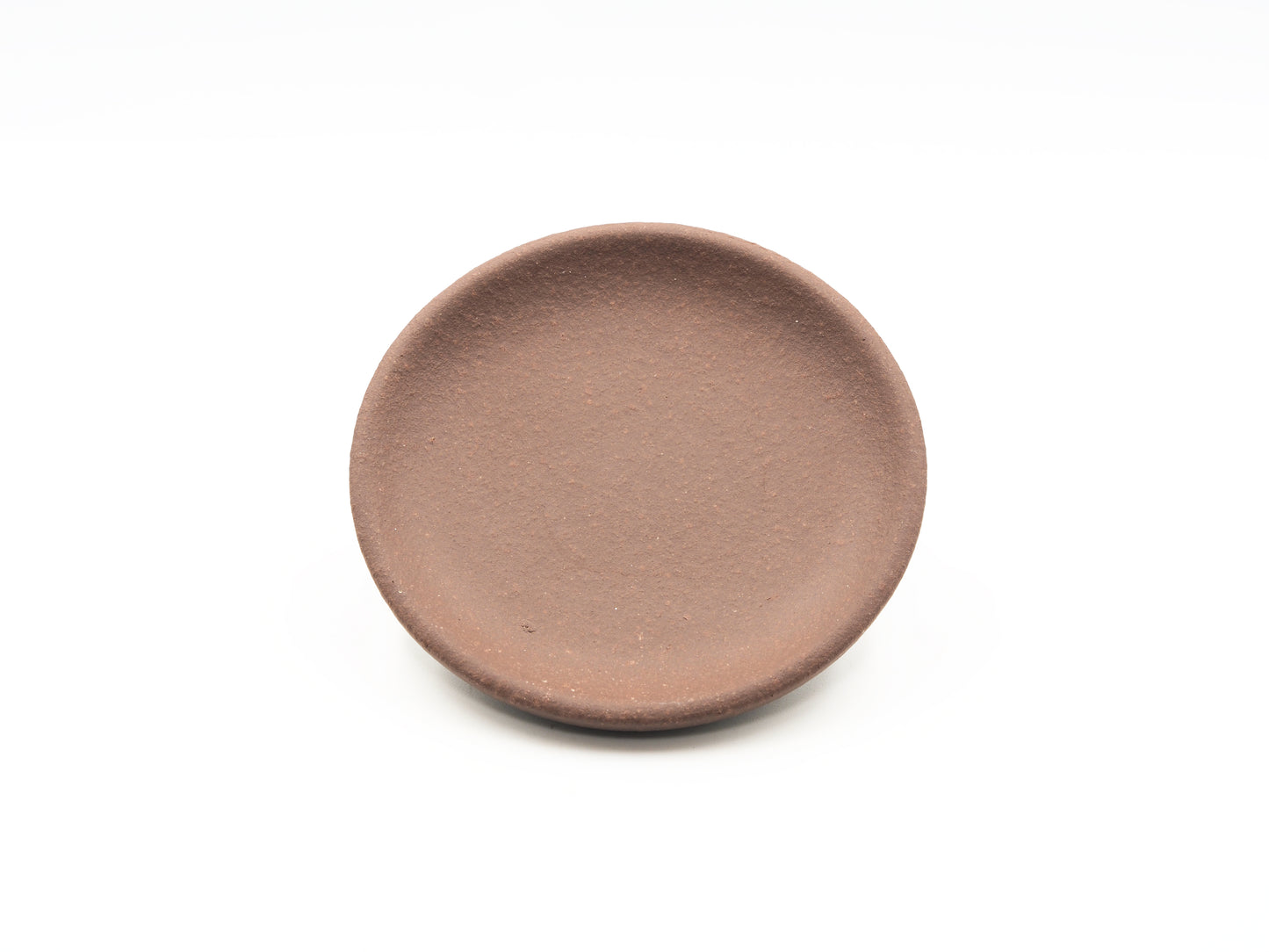 Angled view of round Dehou-style tea coaster in Lao Zini clay