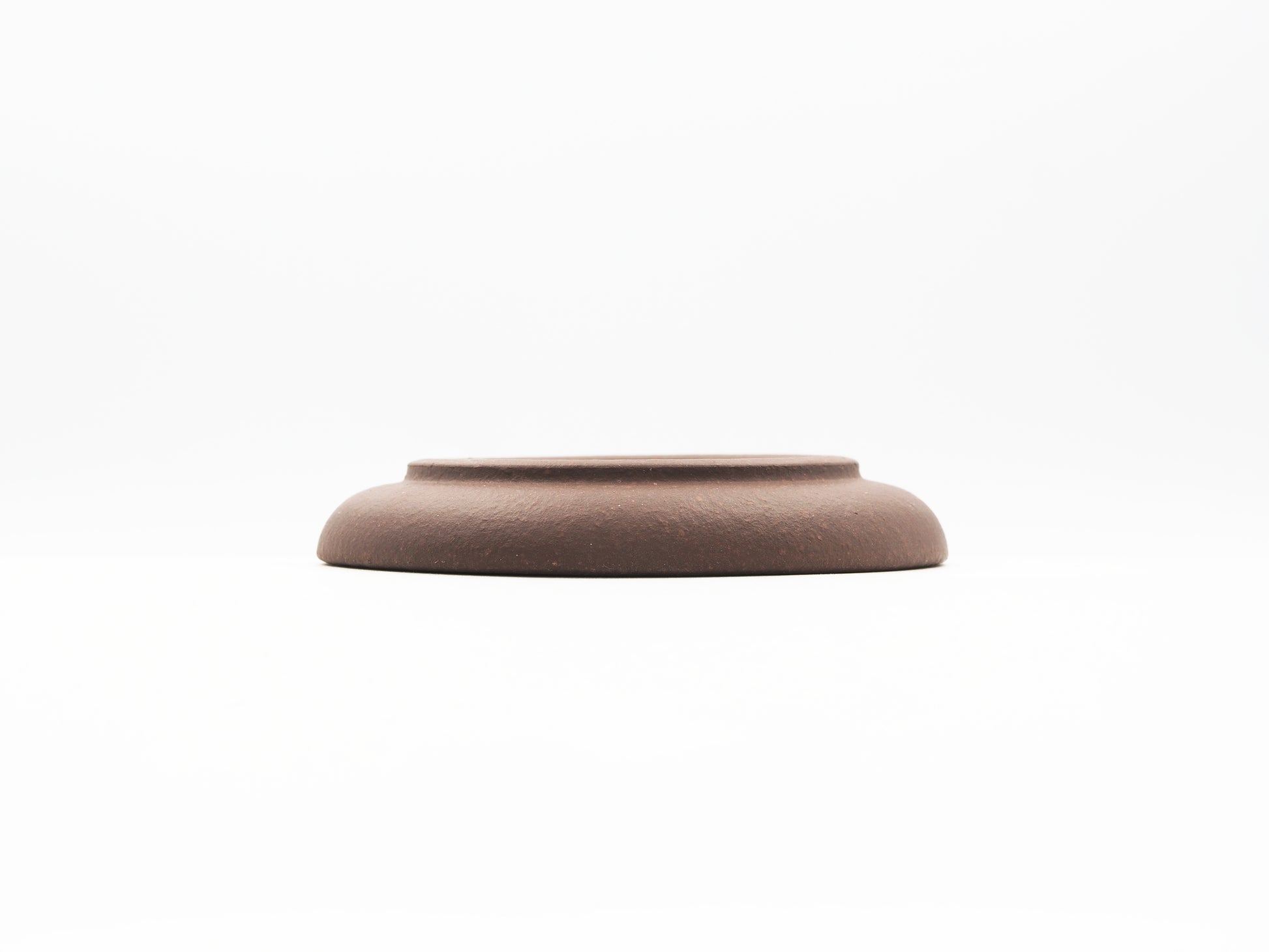 Elevated base view of special grade Lao Zini tea coaster with smooth curve