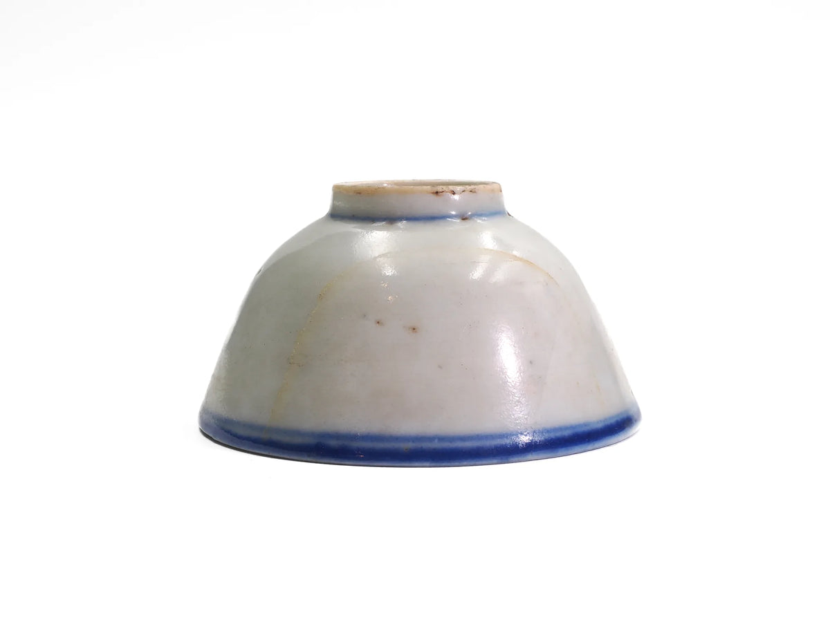 Side view of an upturned antique Late Qing Dynasty Blue Line cup showing the glaze surface, hairline age lines and blue rim band