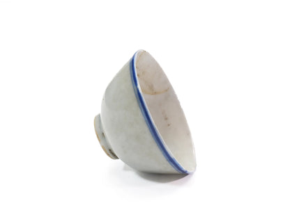 Tilted view of an antique Late Qing Dynasty Blue Line cup showing the inner glaze, natural age marks and single blue rim line