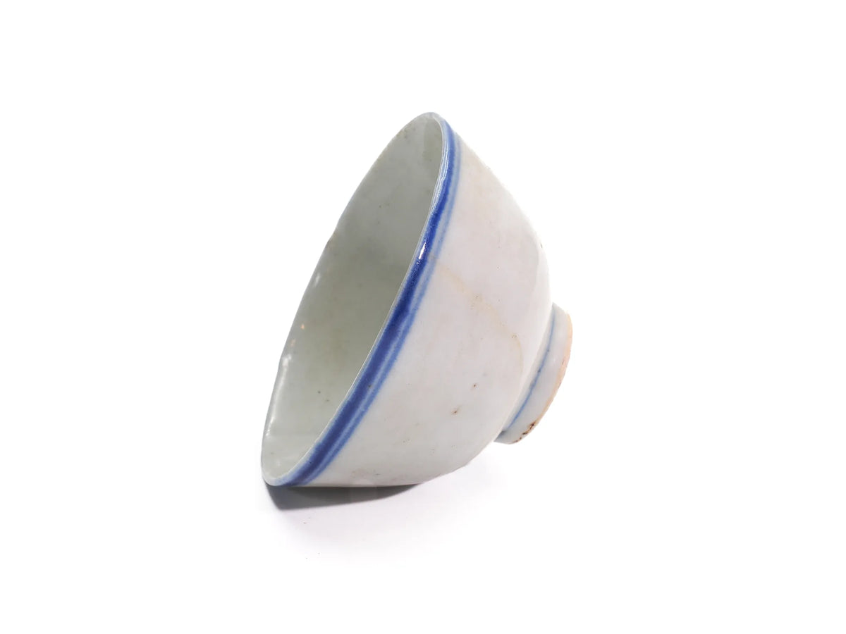 Tilted side view of an antique Late Qing Dynasty Blue Line cup showing the cobalt-blue rim band and pale glazed interior