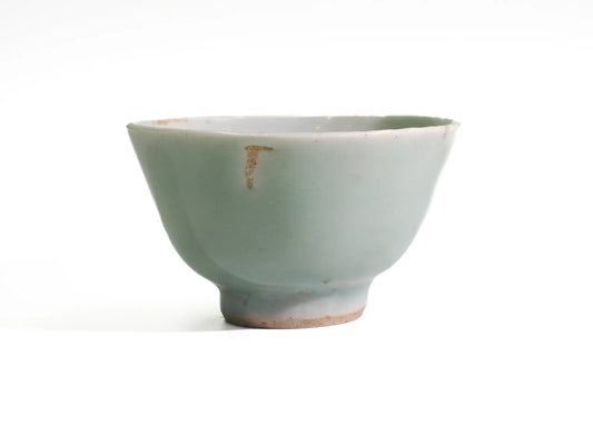 Front view of an antique Mid-Qing Dynasty Celadon cup in soft green celadon glaze with a visible patch of glaze loss near the rim