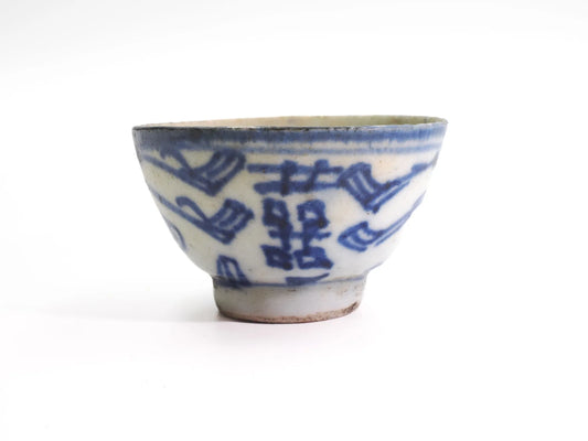 Front view of an antique Mid-Qing Dynasty Double Happiness cup with hand-painted cobalt-blue Shuangxi (囍) character on white porcelain