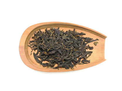 Dry Nan Shan Ji Pin tea leaves displayed on bamboo tray