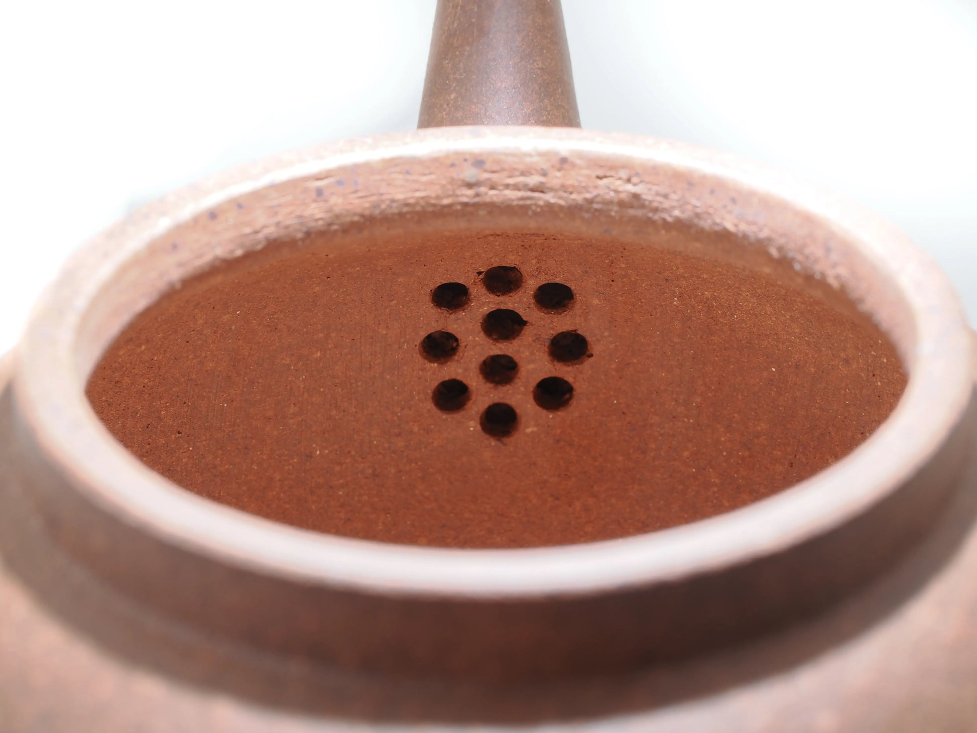 Close-up of the internal filter holes inside the Silver Grade teapot, demonstrating the clean clay work.