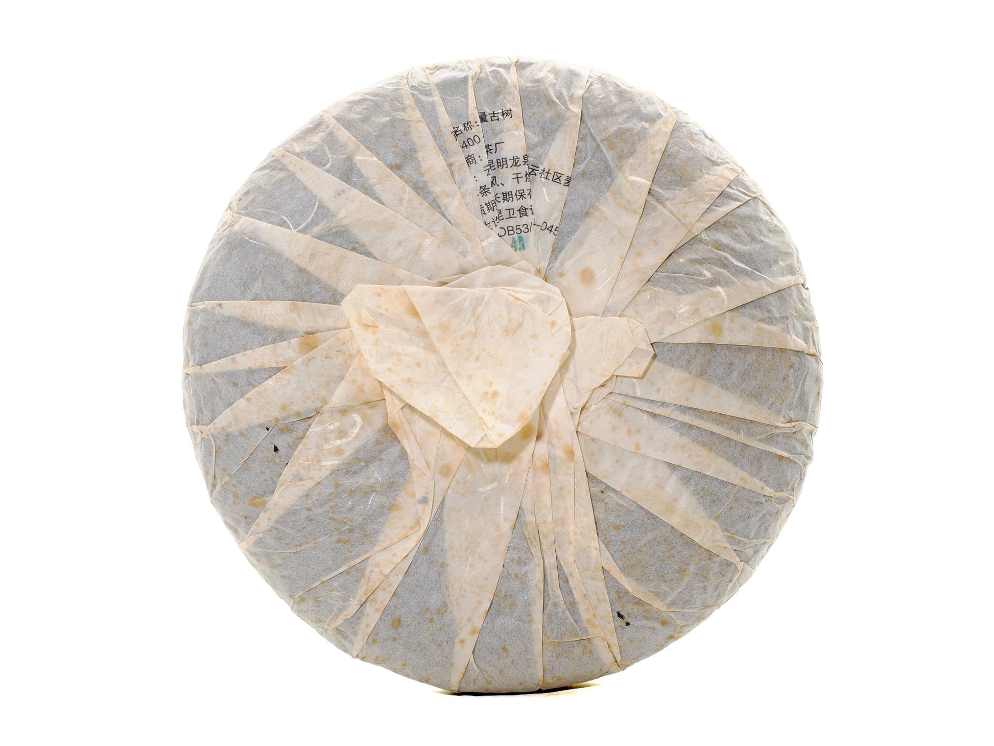 Back view of wrapped 2008 Wuliang Gushu Pu-erh Tea Cake showing traditional folded paper wrapping