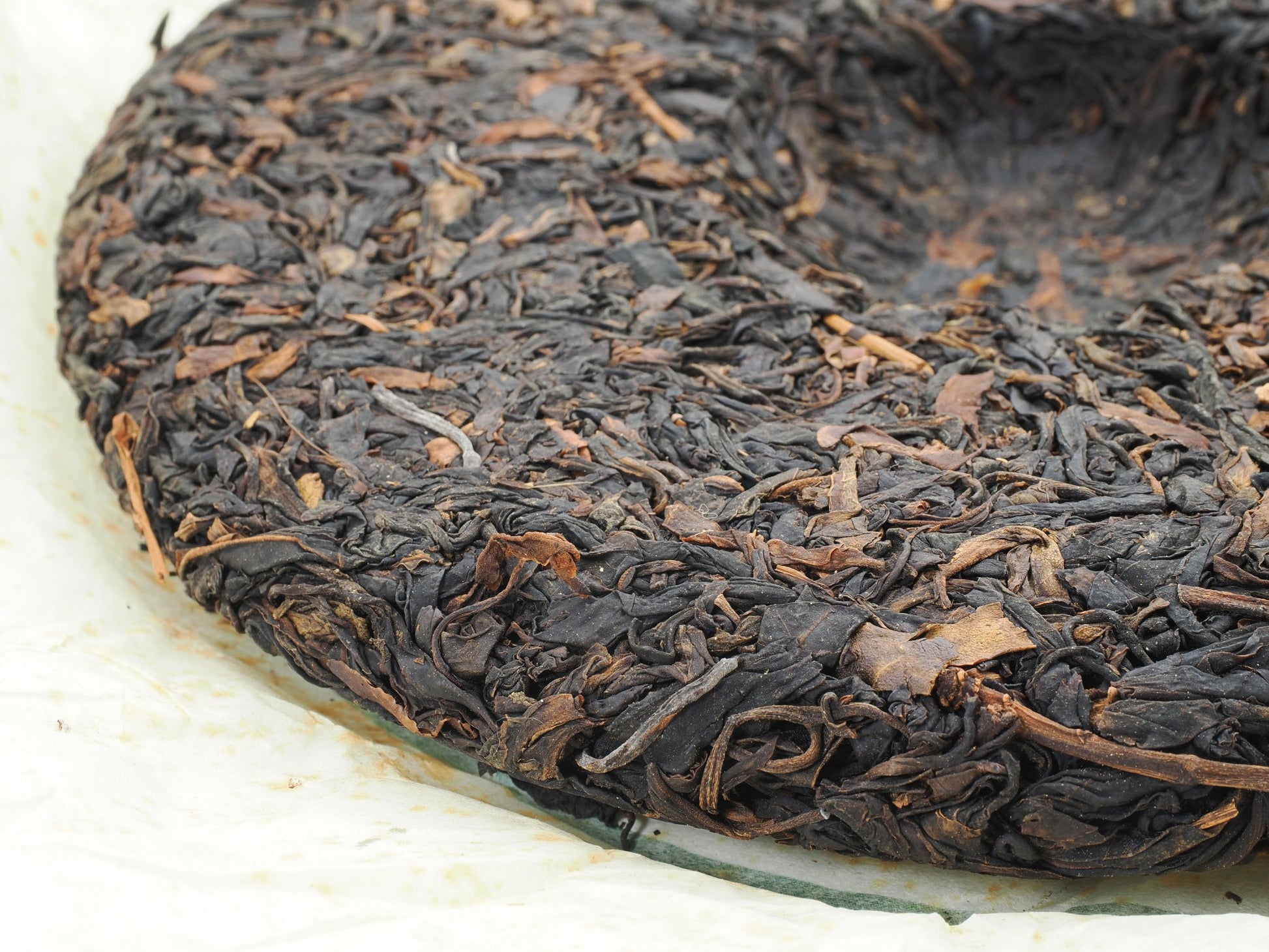 Close-up of tea leaf texture on 2008 Wuliang Gushu Pu-erh Tea Cake, showing large leaf material and compression detail