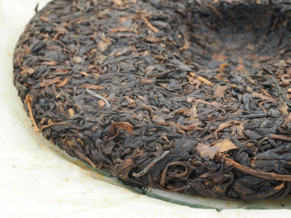 Close-up of tea leaf texture on 2008 Wuliang Gushu Pu-erh Tea Cake, showing large leaf material and compression detail