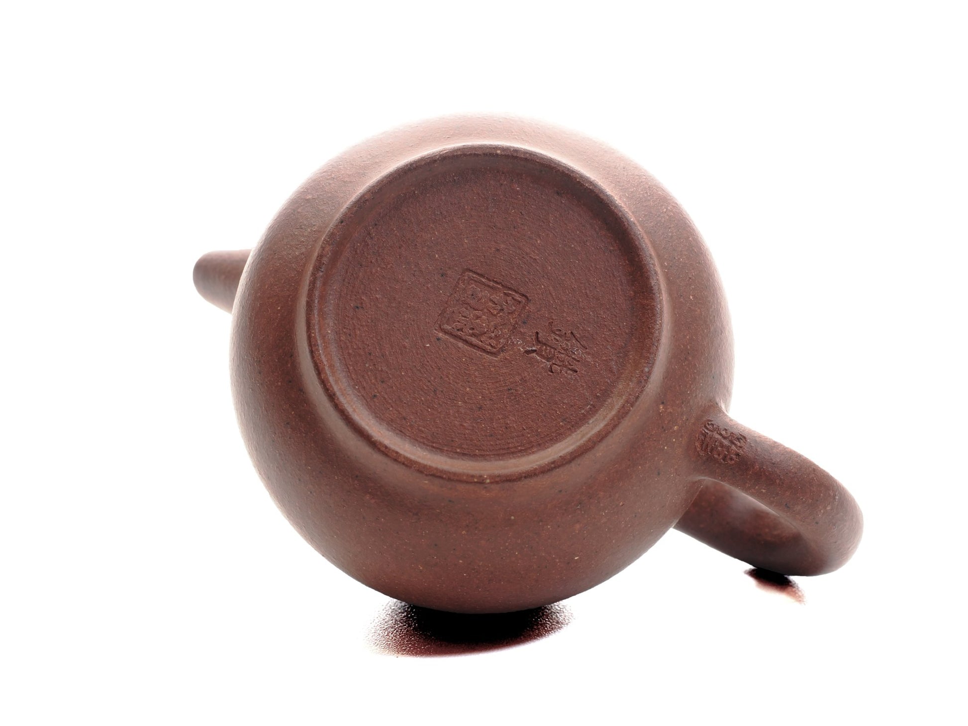 Base of the Xiao Da Bin 50 ml Yixing teapot showing the artisan’s seal stamped into the diamond‑grade purple clay.