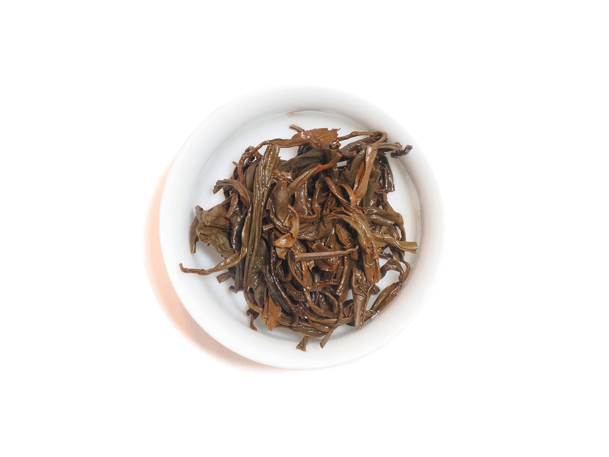 Wet leaves of Yixing Gong Hong black tea after infusion in a white teacup