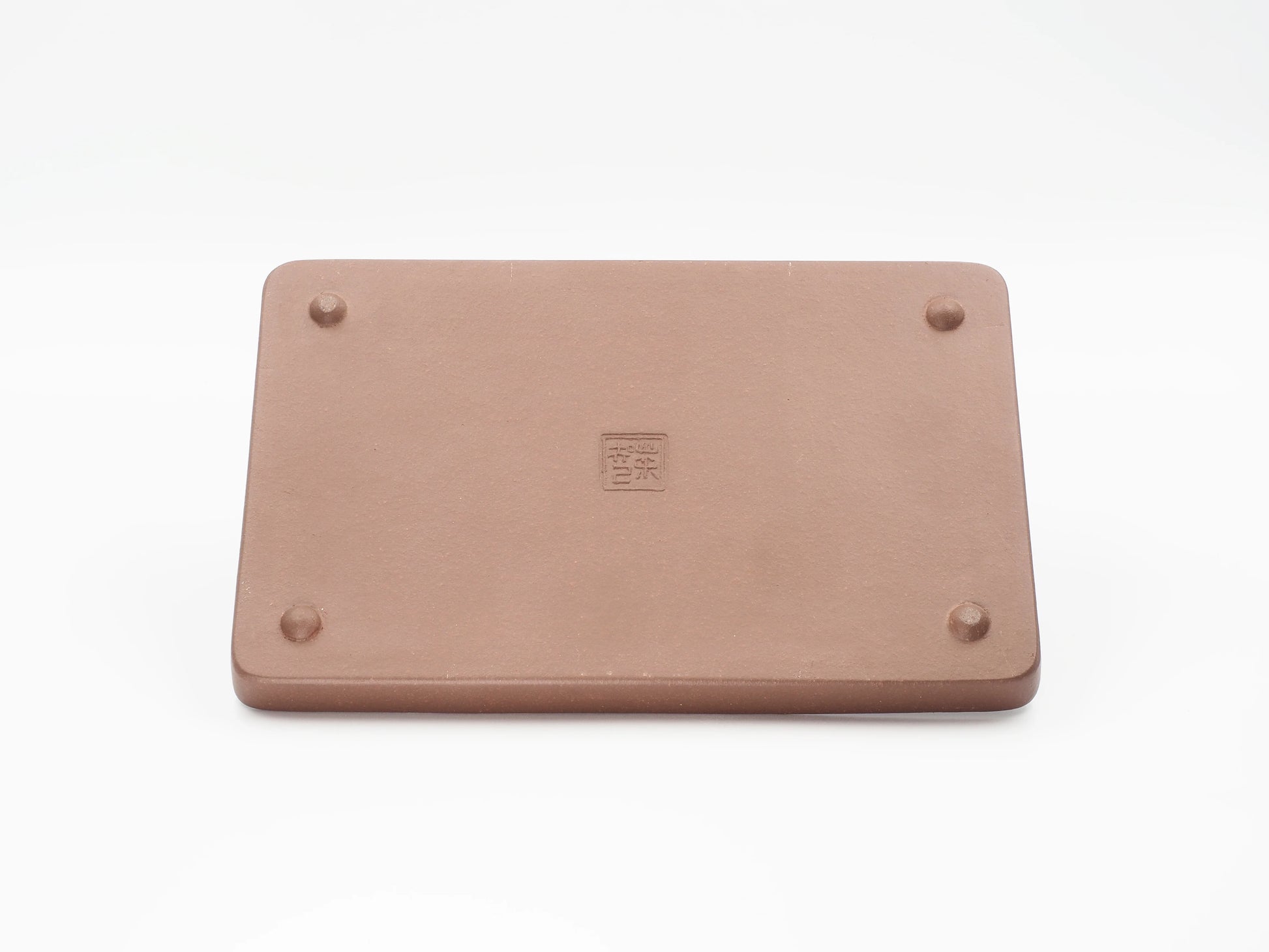 Underside of the Yixing clay tea tray showing the artisan's seal stamp and feet