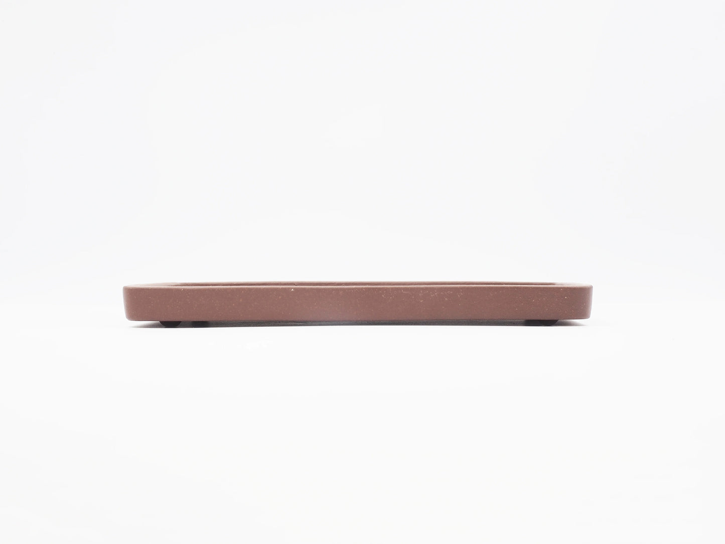 Side profile of the Yixing clay tea tray showing its low, thin form