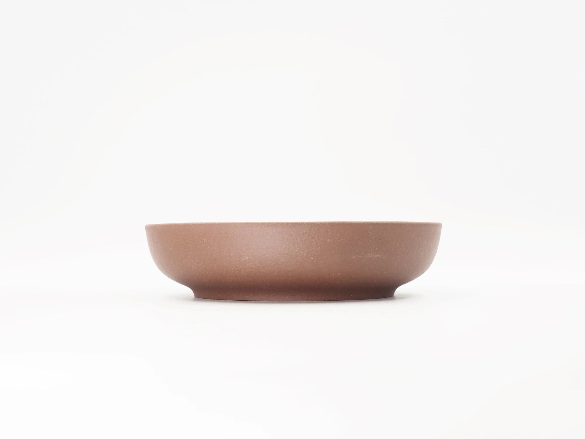 Side profile of the Yixing clay tea boat showing its low, rounded form